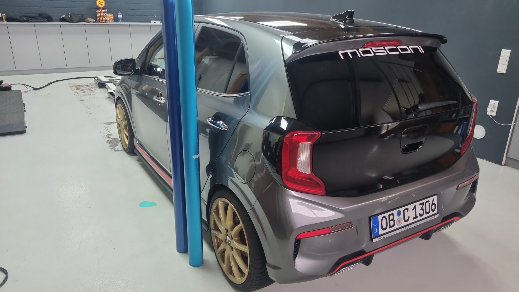 Anthrazit folierter Kia Picanto mit goldenen Felgen in der Werkstatt